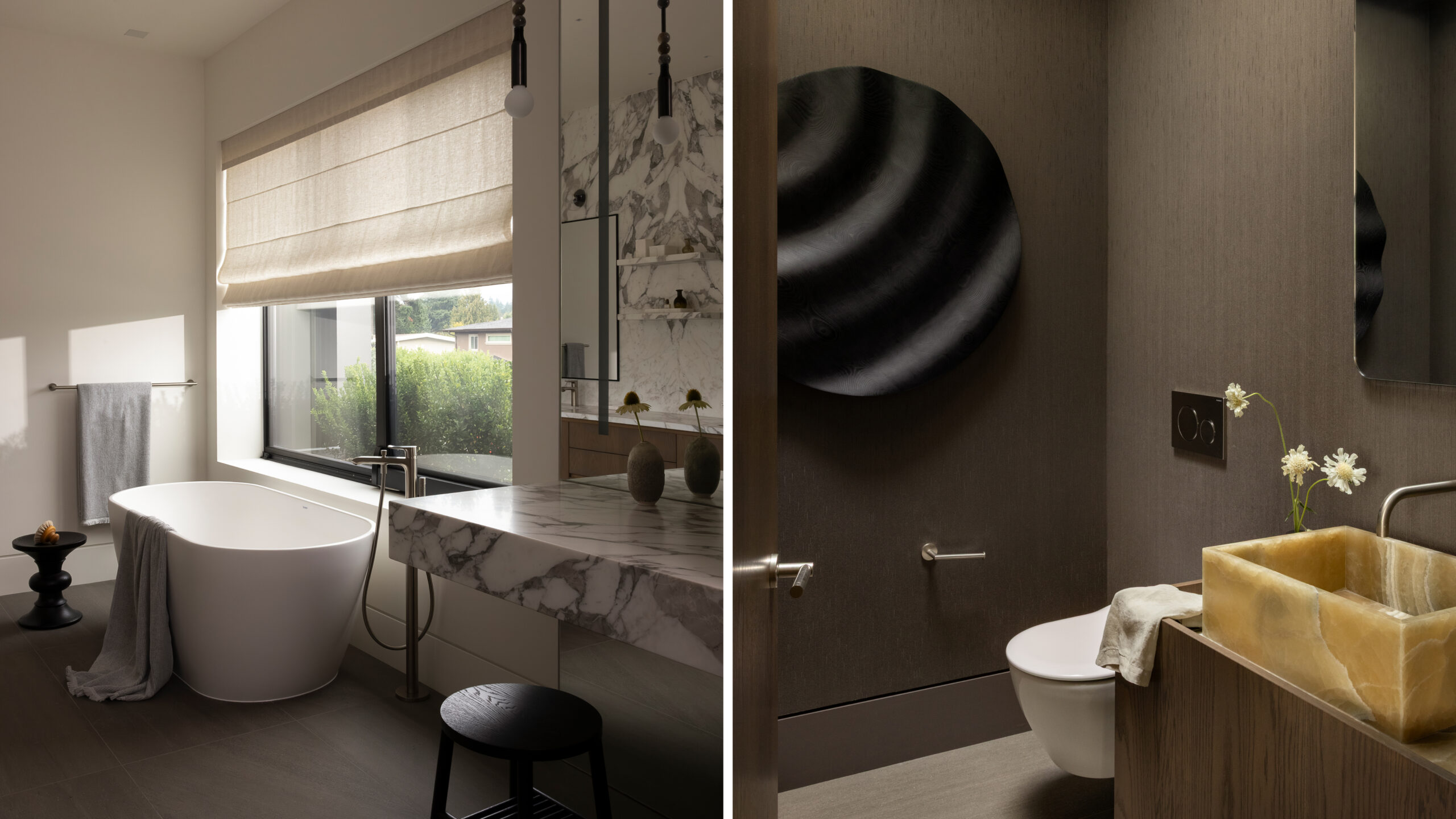 Modern bathroom with a freestanding tub by a large window, light beige roman shade, and marble vanity top.